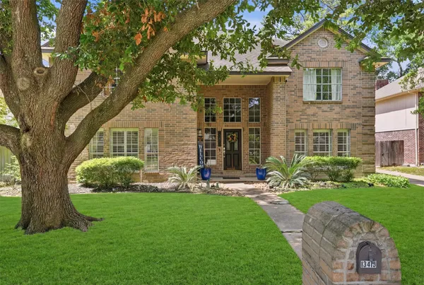 a front view of a house with a yard and trees