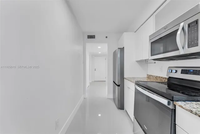 a kitchen with stainless steel appliances a refrigerator microwave and sink