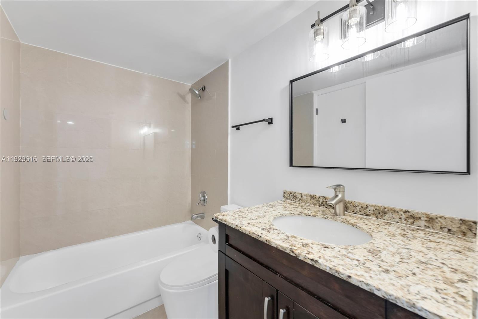 770 Claughton Island Drive, Unit 1401 Miami, FL 33131 - Photo 13 of 31 a bathroom with a granite countertop sink a toilet and a bathtub
