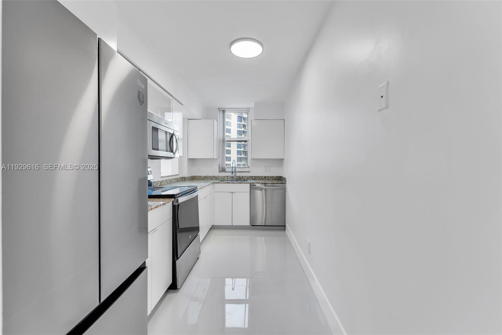 770 Claughton Island Drive, Unit 1401 Miami, FL 33131 - Photo 8 of 31 a kitchen with white cabinets and white appliances