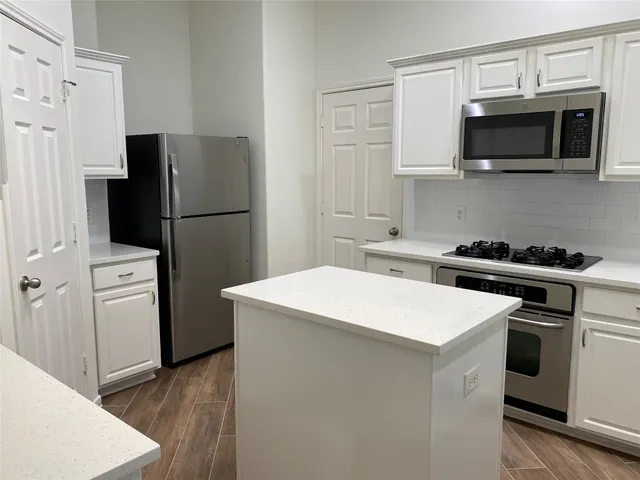 a kitchen with stainless steel appliances a refrigerator stove and microwave