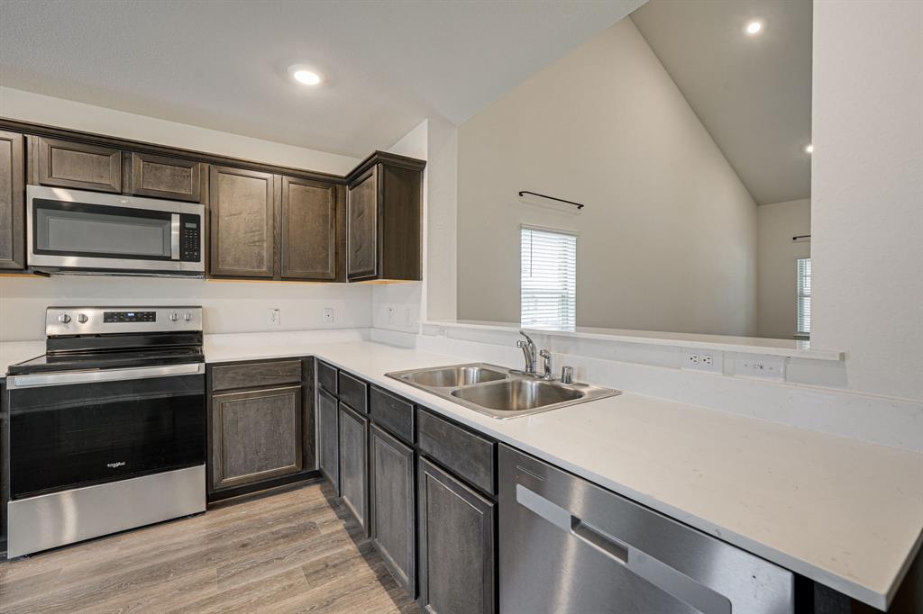 317 Sage Street Anna, TX 75409 - Photo 11 of 33 a kitchen with stainless steel appliances granite countertop a sink and stove top oven