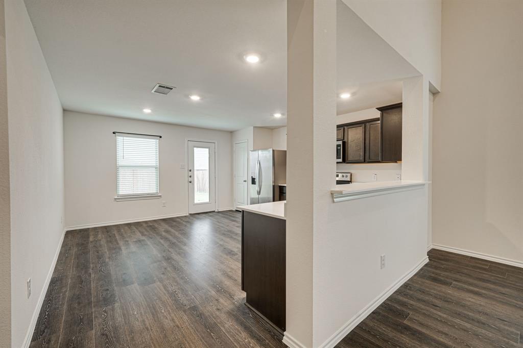 317 Sage Street Anna, TX 75409 - Photo 13 of 33 a view of a hallway with wooden floor and staircase