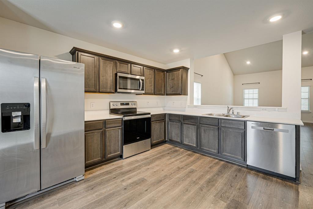 317 Sage Street Anna, TX 75409 - Photo 10 of 33 a large kitchen with stainless steel appliances granite countertop a refrigerator and a stove top oven
