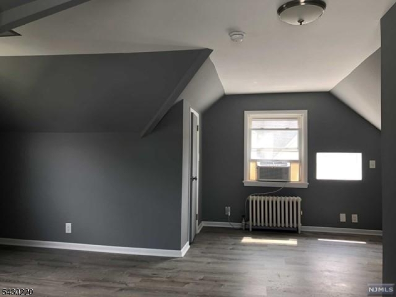 166 Carmita Avenue Rutherford, NJ 07070 - Photo 20 of 27 an empty room with wooden floor and windows