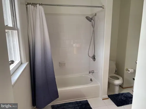 a bathroom with a bath tub a toilet and a shower