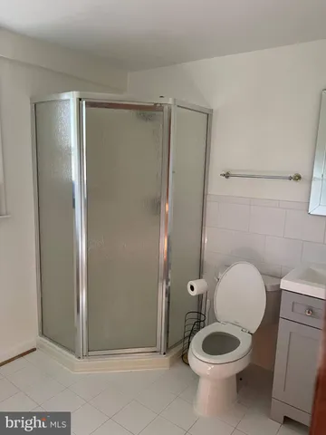 a bathroom with a granite countertop toilet and a shower