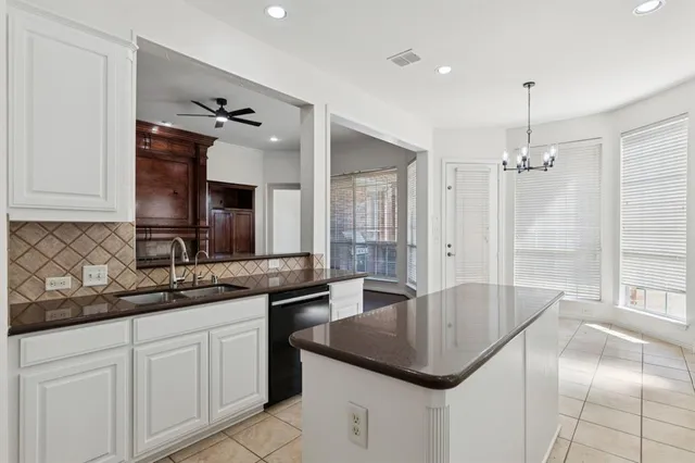 a kitchen with stainless steel appliances granite countertop a sink a counter space and a window