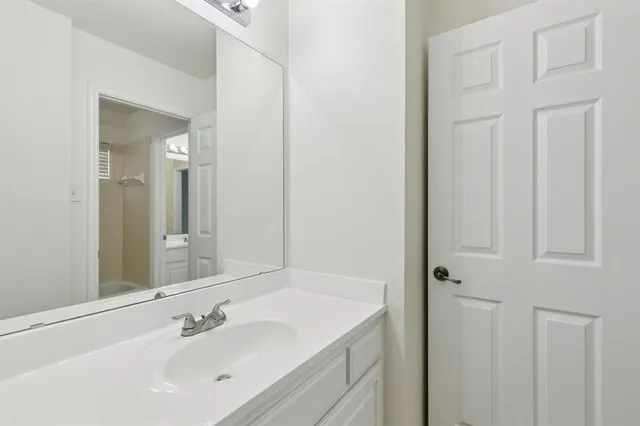 an empty room with wooden floor cabinet and windows