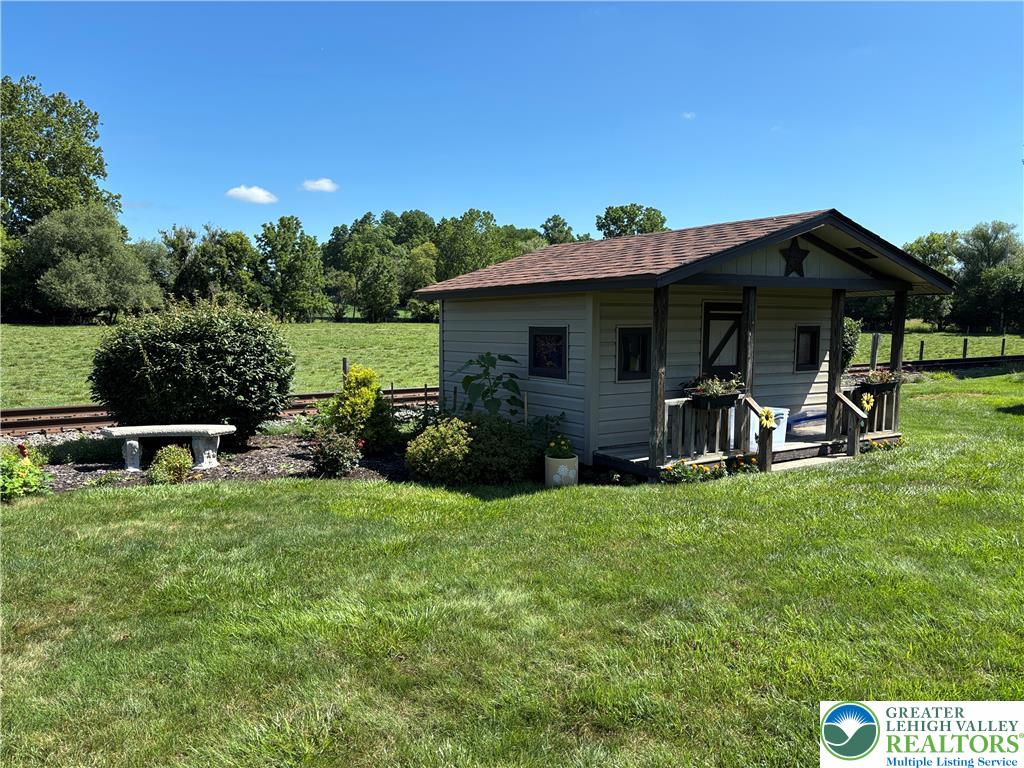 4938 Steuben Road Nazareth, PA 18064 - Photo 6 of 8 A charming playhouse with a welcoming porch sits nestled in a verdant landscape.