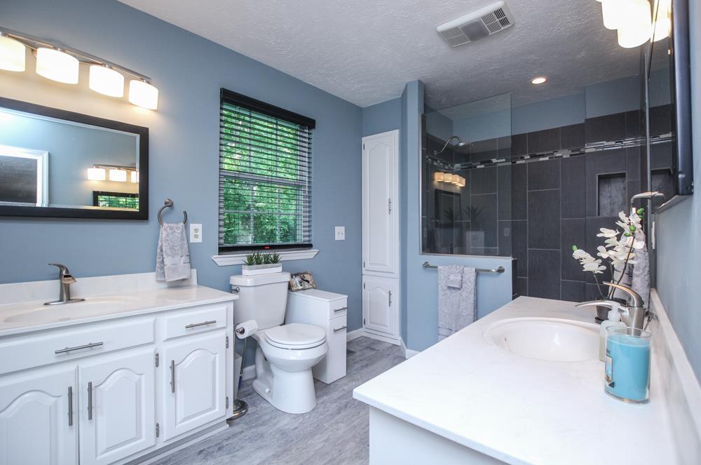 496 Horn Springs Road Lebanon, TN 37087 - Photo 19 of 30 a bathroom with a double vanity sink a toilet a mirror and shower