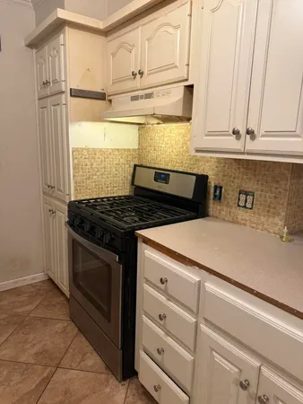 a kitchen with granite countertop white cabinets and white appliances