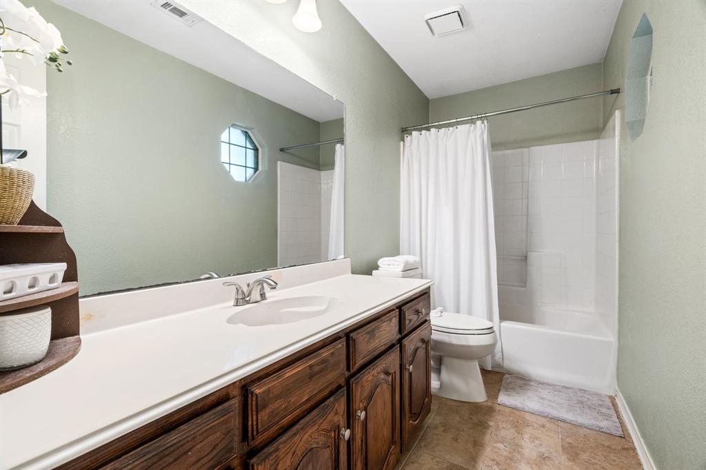 2302 Randi Road Rowlett, TX 75088 - Photo 21 of 33 a bathroom with a sink a toilet and a mirror