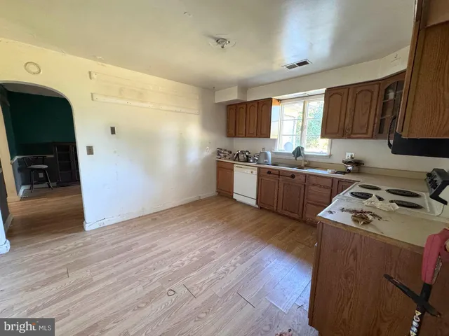 a kitchen with stainless steel appliances granite countertop wooden cabinets stove top oven and sink