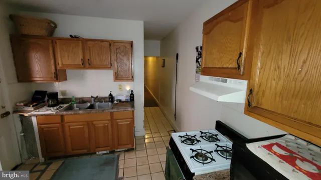a kitchen with a stove a refrigerator and wooden cabinets