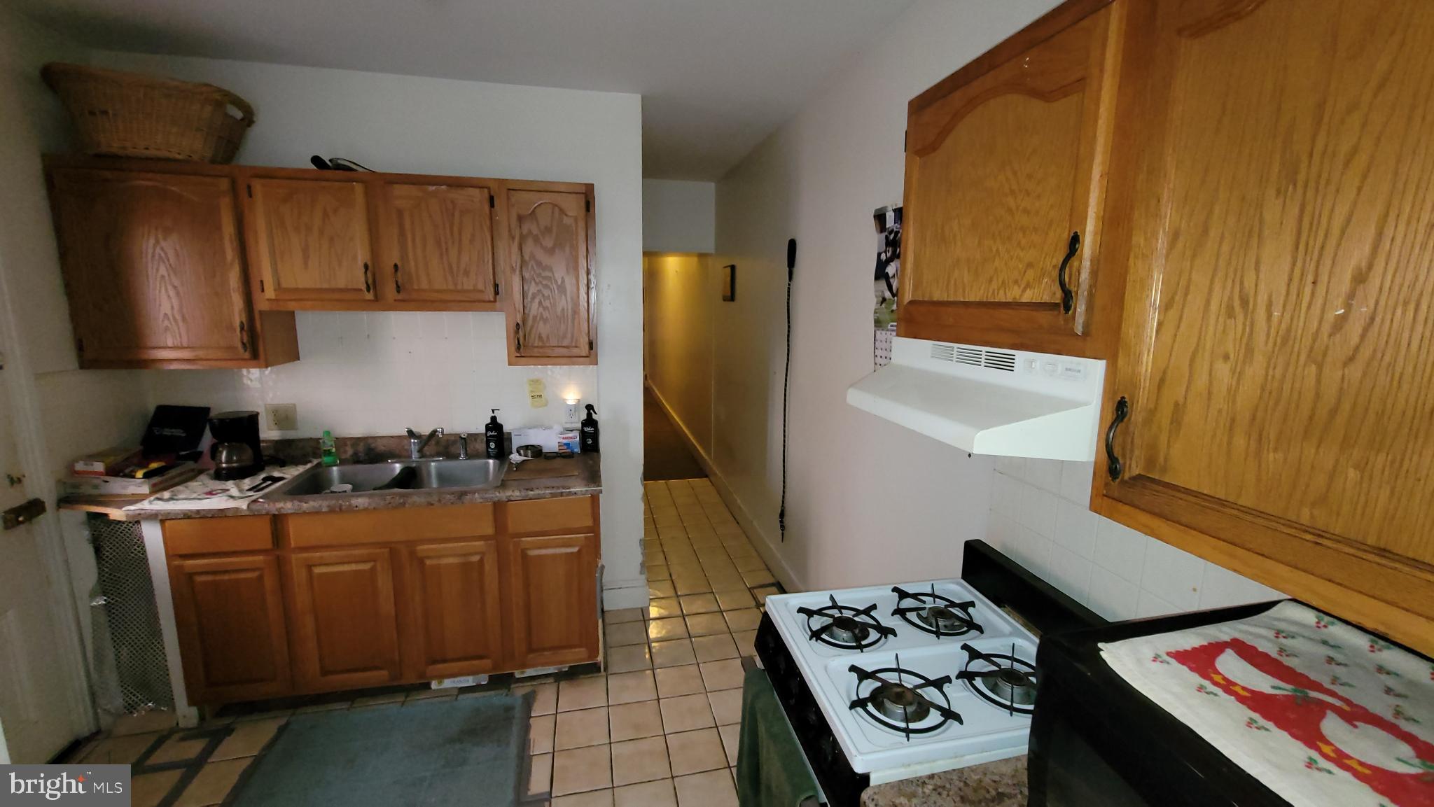 146 North 5th Street Reading, PA 19601 - Photo 13 of 53 a kitchen with a stove a refrigerator and wooden cabinets