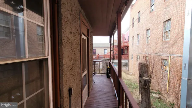 a view of balcony with wooden floor and bench