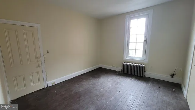 a view of a hallway with wooden floor and stairs