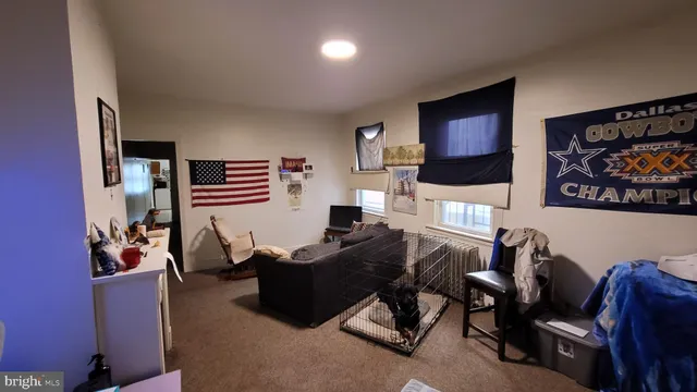 a living room with furniture a flat screen tv and kitchen view