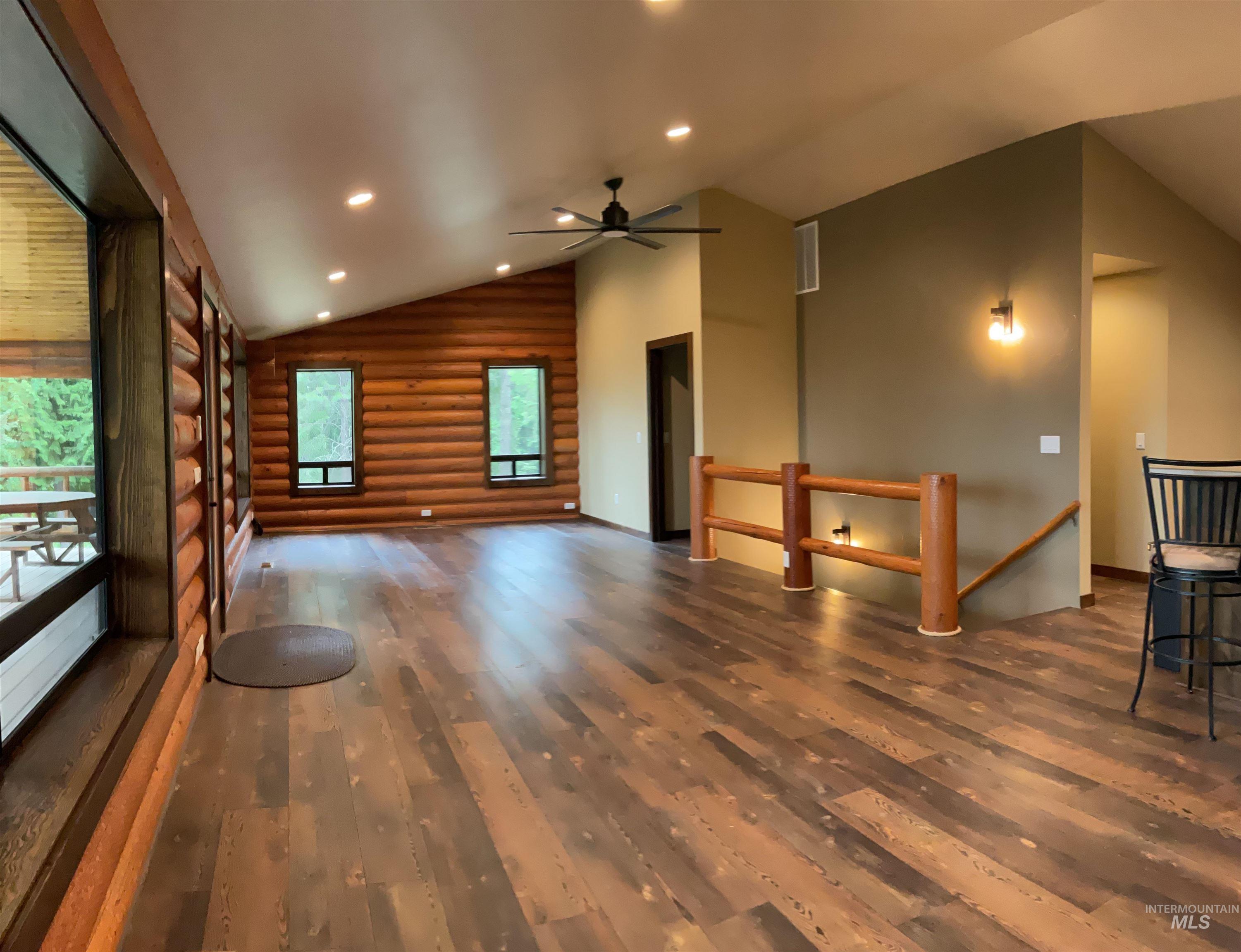 6125 Freeman Creek Road Lenore, ID 83541 - Photo 11 of 44 Spacious living area featuring wood-finish flooring, log walls, and an angled ceiling