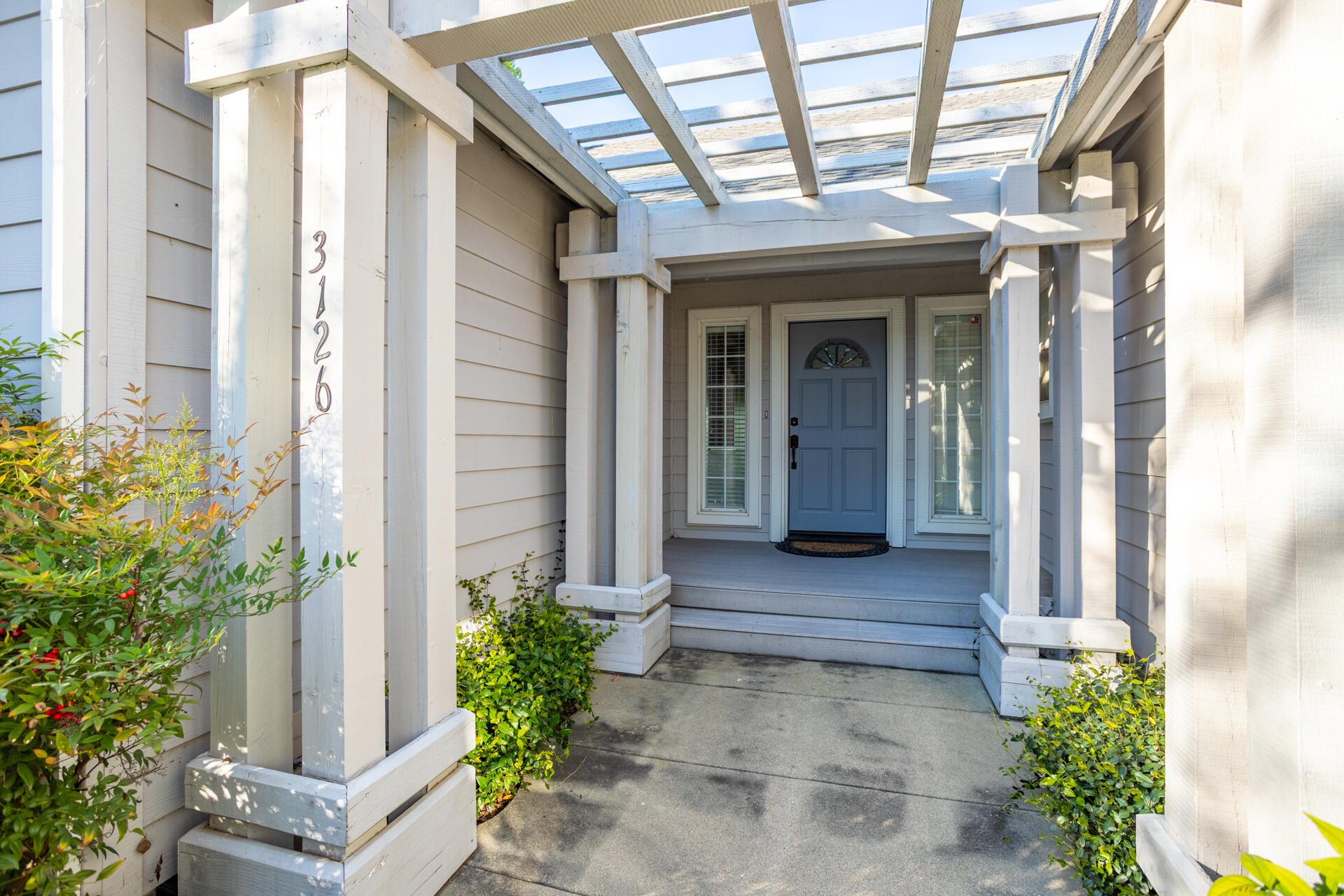 3126 Riesling Path Redding, CA 96001 - Photo 2 of 32 a view of a brick house with potted plants and a table and chairs