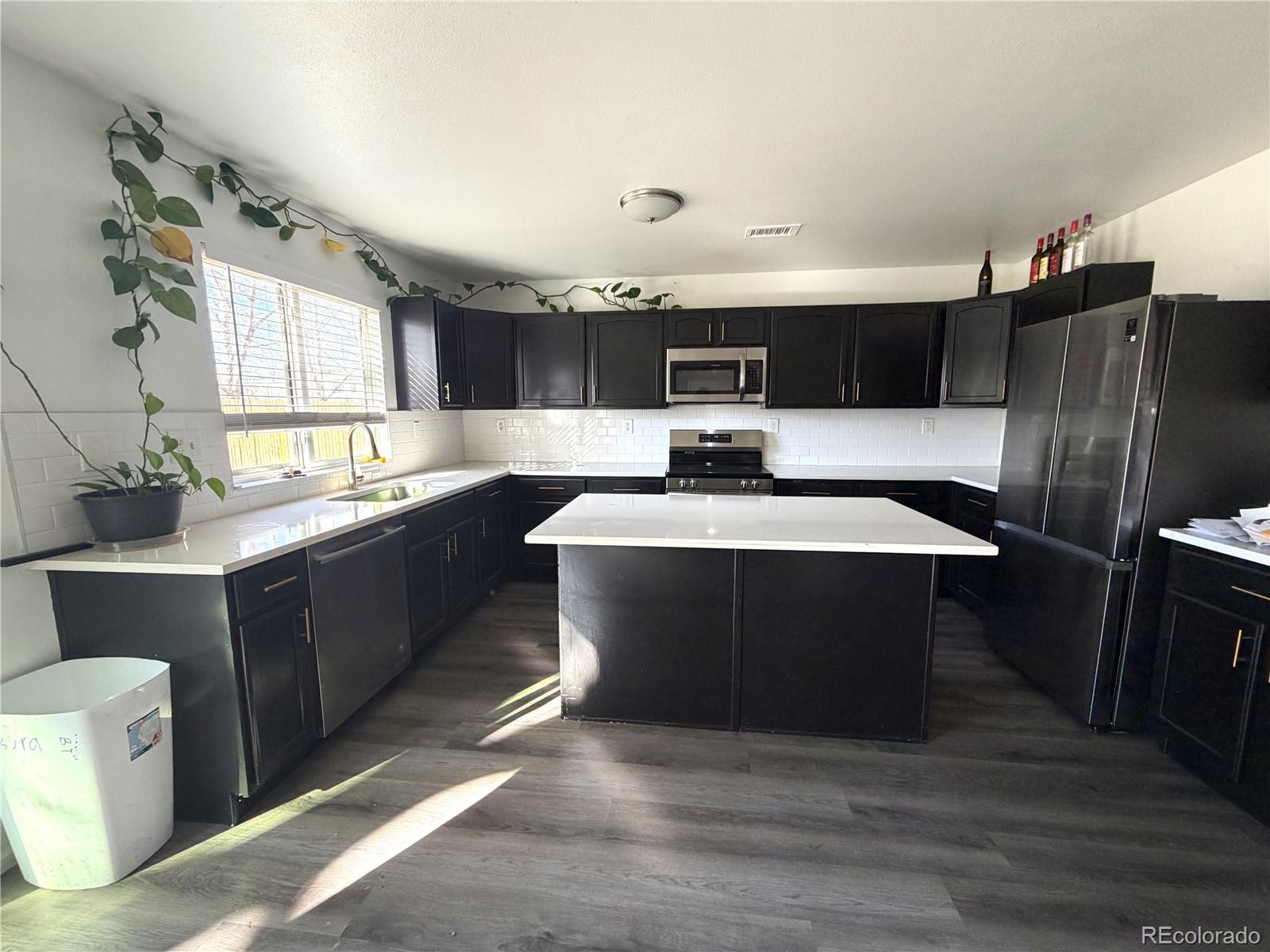 4839 Liverpool Street Denver, CO 80249 - Photo 2 of 6 a kitchen with stainless steel appliances granite countertop a sink a stove a refrigerator and cabinets