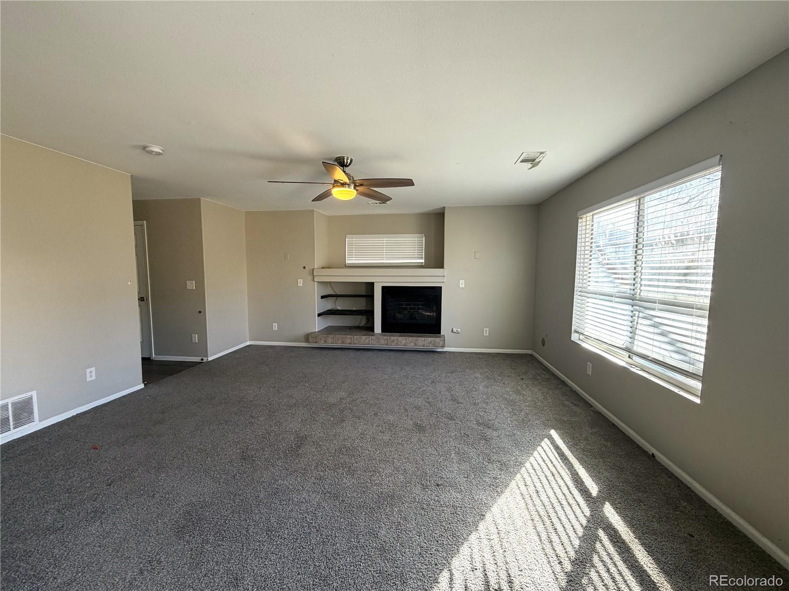 4839 Liverpool Street Denver, CO 80249 - Photo 3 of 6 a view of empty room with fireplace