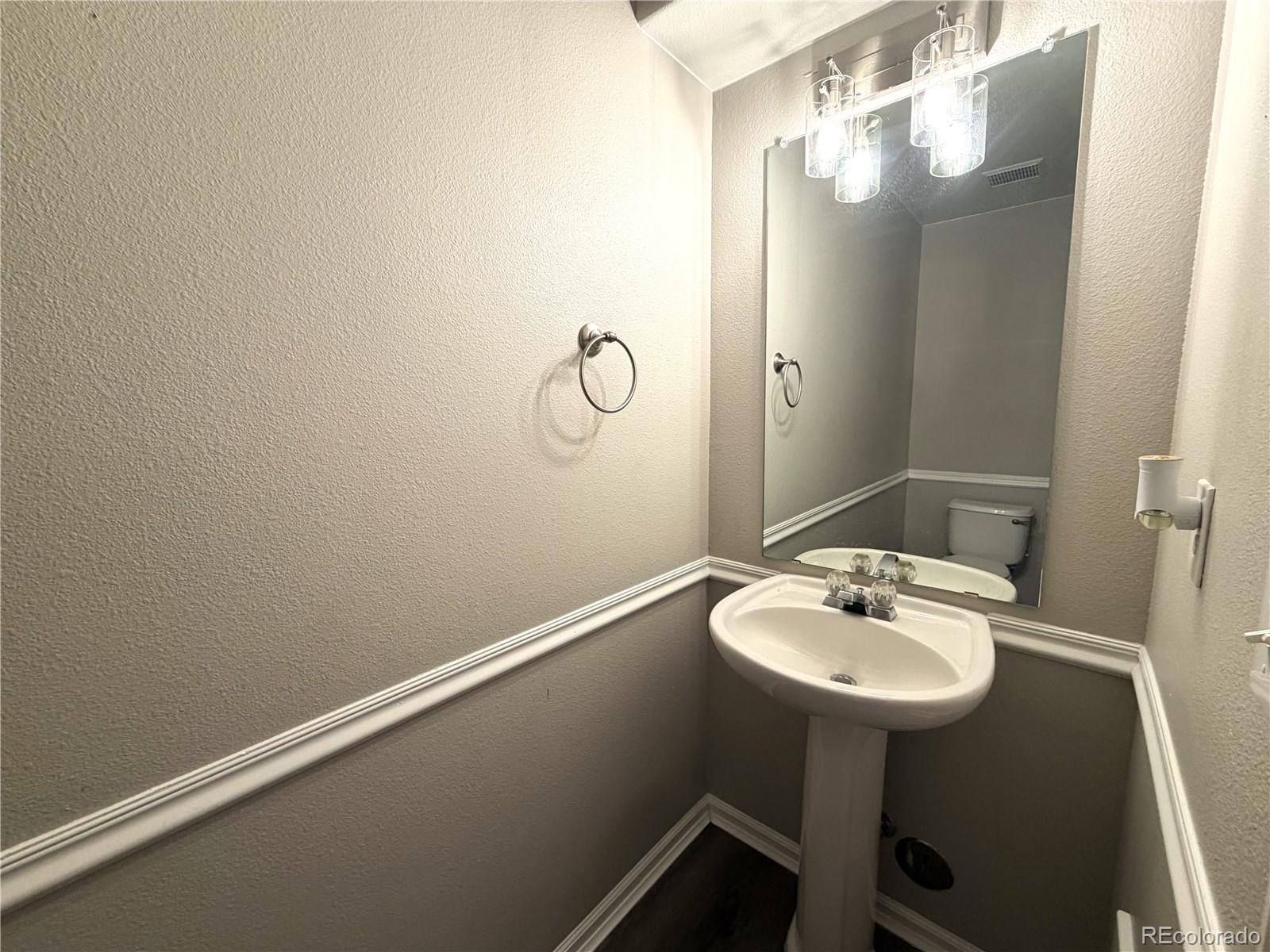 4839 Liverpool Street Denver, CO 80249 - Photo 4 of 6 a bathroom with a sink and mirror