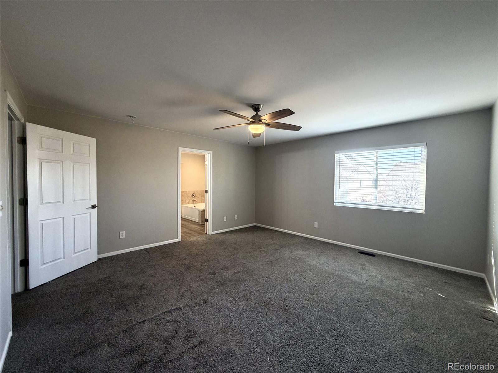 4839 Liverpool Street Denver, CO 80249 - Photo 5 of 6 an empty room with windows and fan