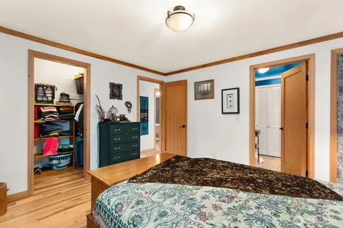 a bedroom with a bed and wooden floor