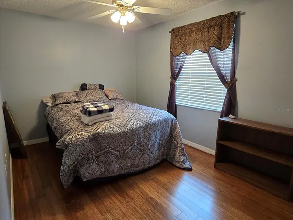 a bedroom with a bed and wooden floor