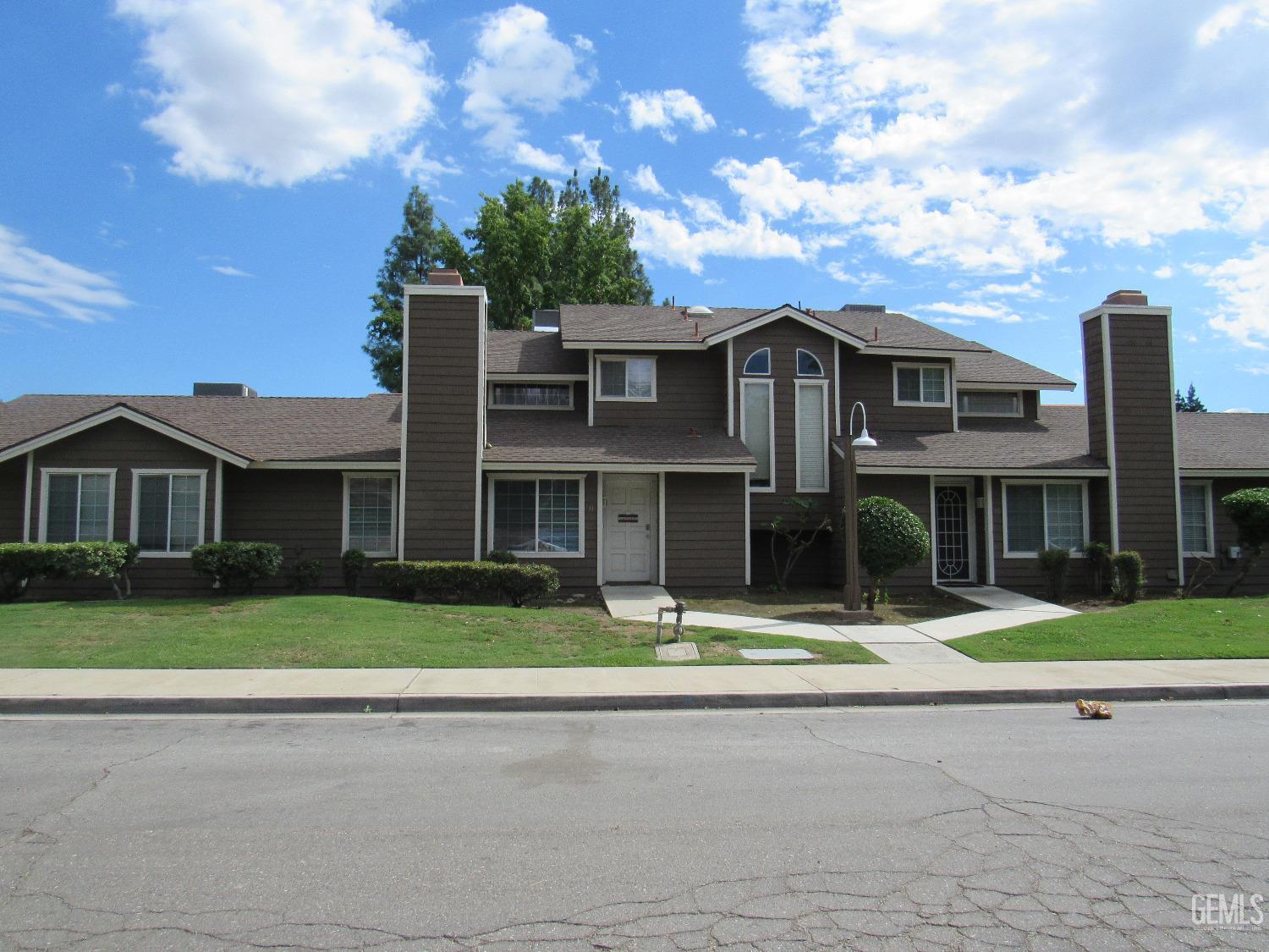 a front view of residential houses with yard and green space