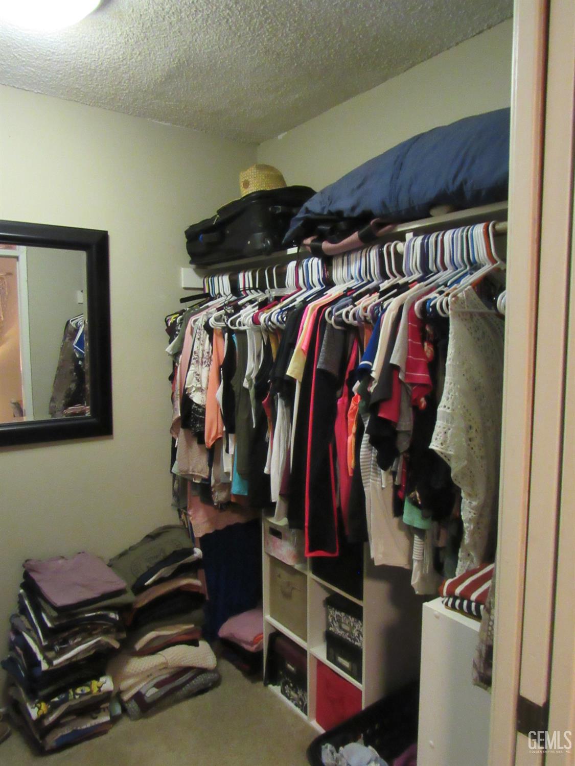 Undisclosed Address Bakersfield, CA 93309 - Photo 15 of 25 a view of walk in closet with clothes and shoes