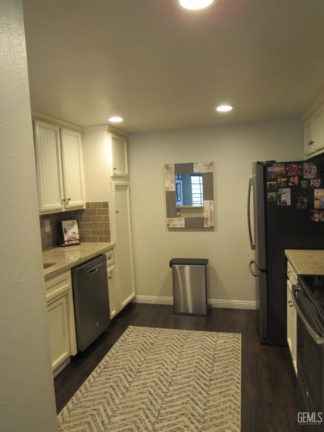 Undisclosed Address Bakersfield, CA 93309 - Photo 5 of 25 a kitchen with a refrigerator and white cabinets