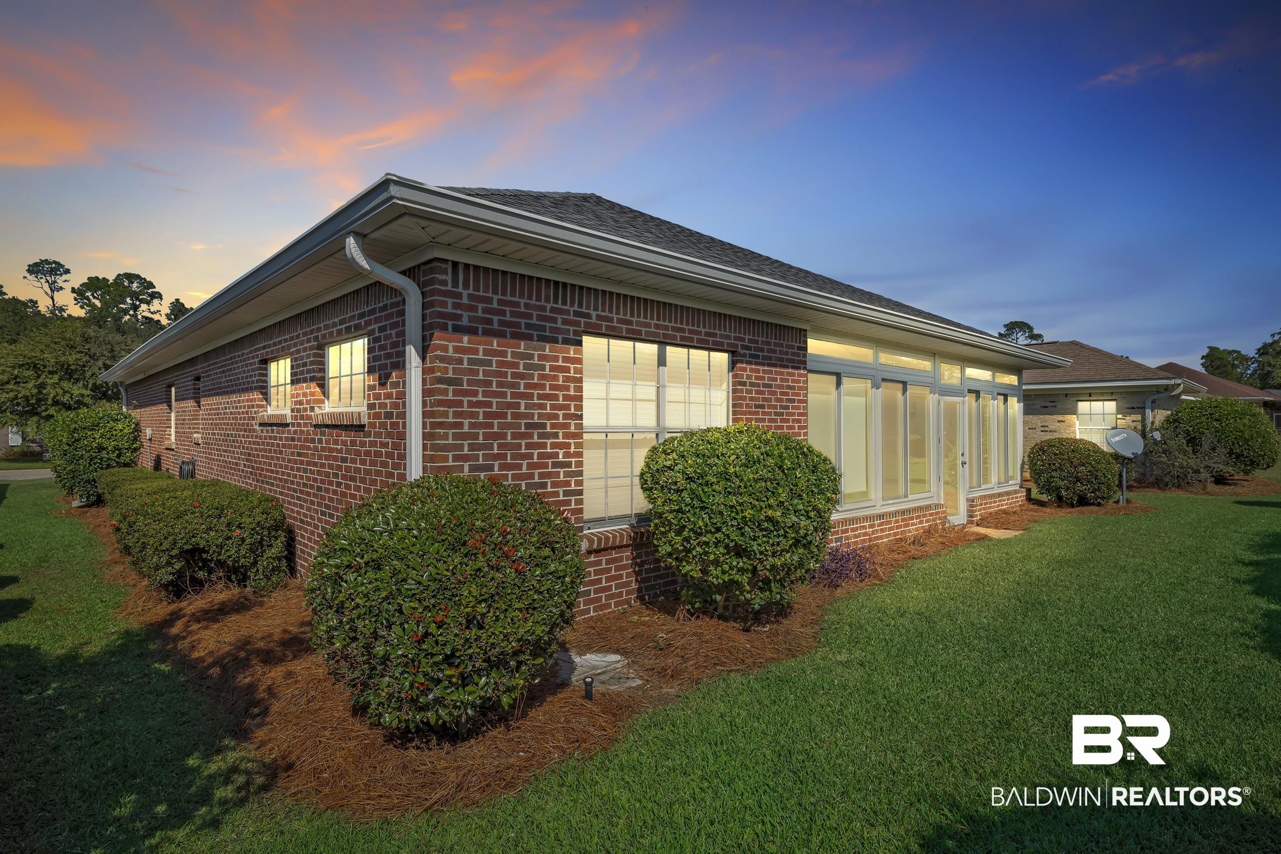 226 Hemingway Loop Foley, AL 36535 - Photo 40 of 53 Property exterior at dusk featuring brick siding, a yard, and a shingled roof