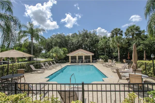 a view of a patio with a table and chairs under an umbrella with wooden fence