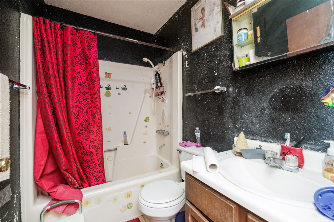 1007 Ross Street George West, TX 78022 - Photo 19 of 24 a white toilet sitting next to a bathroom sink and vanity