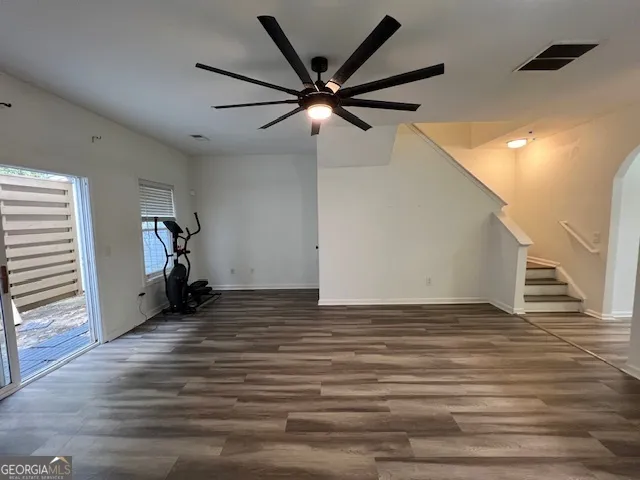 a view of a livingroom with wooden floor and ceiling fan