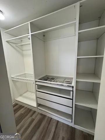 a view of walk in closet with empty racks