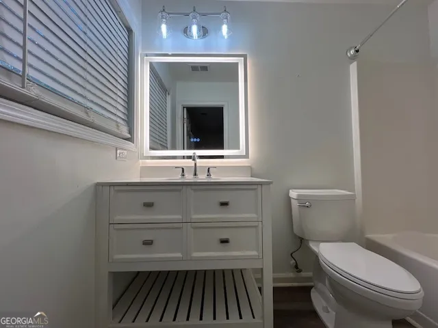 a bathroom with a toilet a sink and mirror