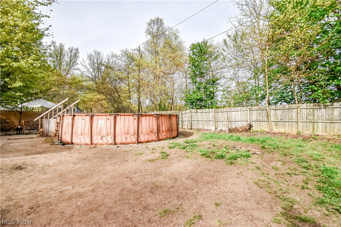 1969 Paisley Road Madison, OH 44057 - Photo 19 of 20 Expansive backyard featuring a wood-sided above-ground pool with a wood-plank deck and stairs