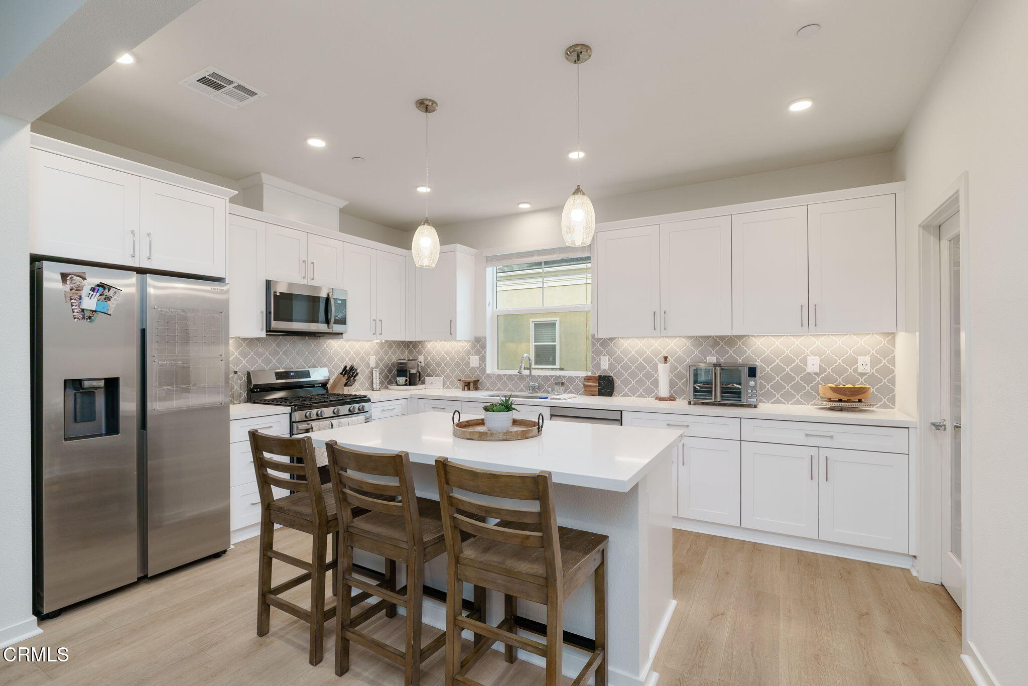 751 Winchester Drive Oxnard, CA 93036 - Photo 12 of 33 a kitchen with white cabinets and stainless steel appliances