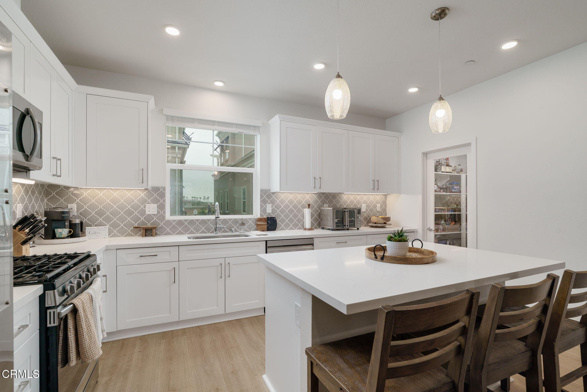 751 Winchester Drive Oxnard, CA 93036 - Photo 13 of 33 a kitchen with a stove a sink a dining table and chairs