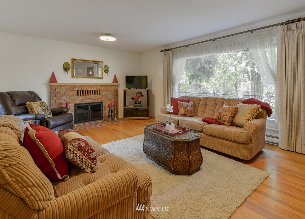 15256 Southeast 116th Street Renton, WA 98059 - Photo 25 of 38 a living room with furniture large window and a fireplace