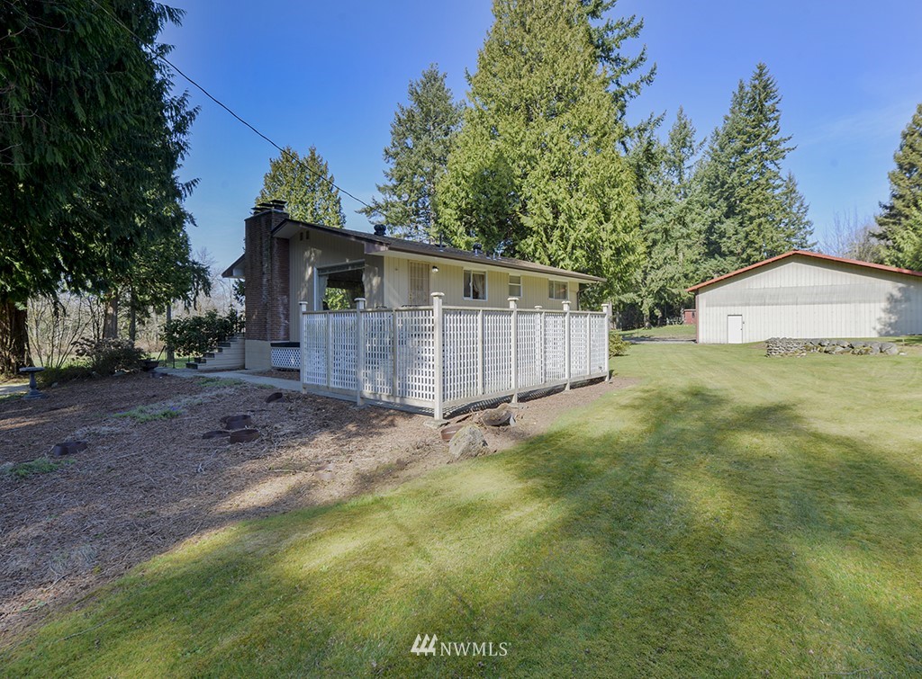 15256 Southeast 116th Street Renton, WA 98059 - Photo 4 of 38 a view of a barn in the backyard with large tree and wooden fence