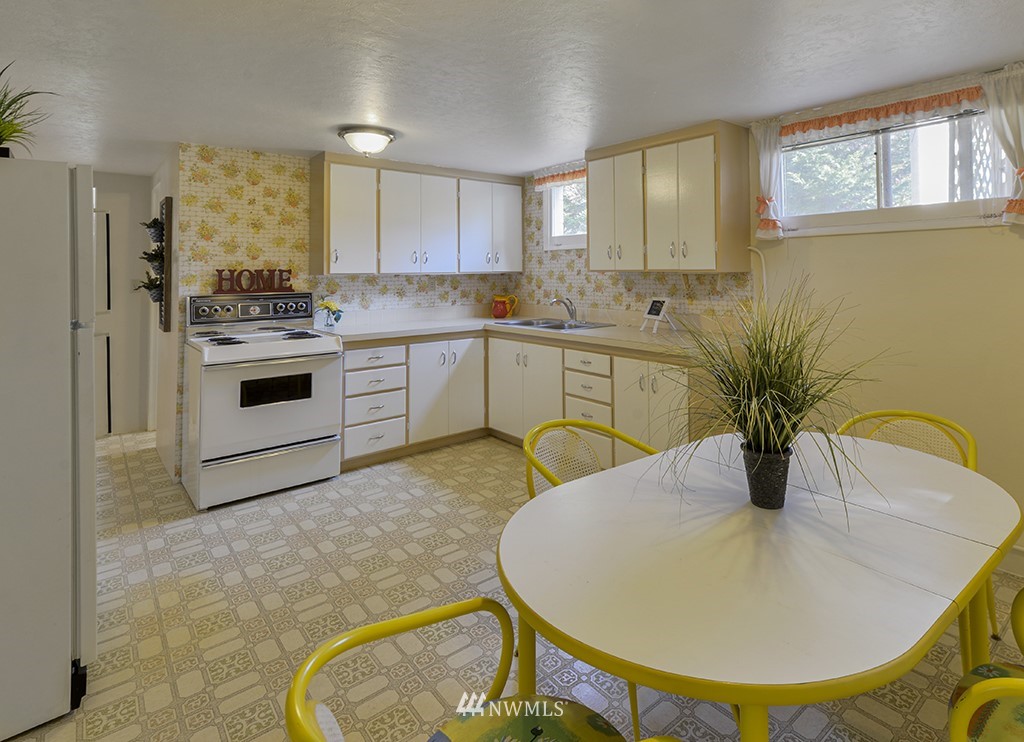 15256 Southeast 116th Street Renton, WA 98059 - Photo 10 of 38 a kitchen with stainless steel appliances granite countertop a sink a stove a dining table and chairs