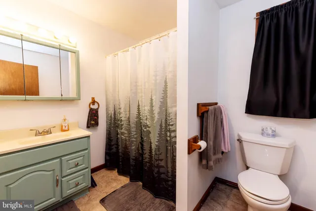 a bathroom with a toilet a sink and glass door