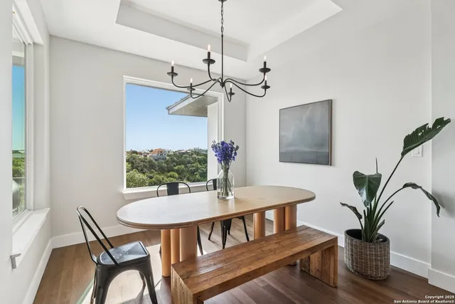 a dining room with furniture and potted plants