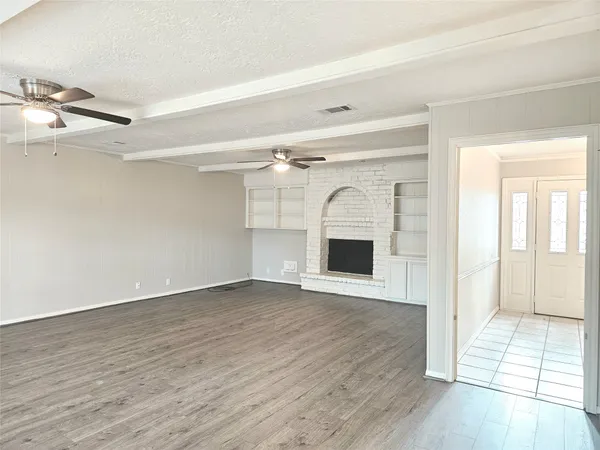 a view of a livingroom with wooden floor and a ceiling fan