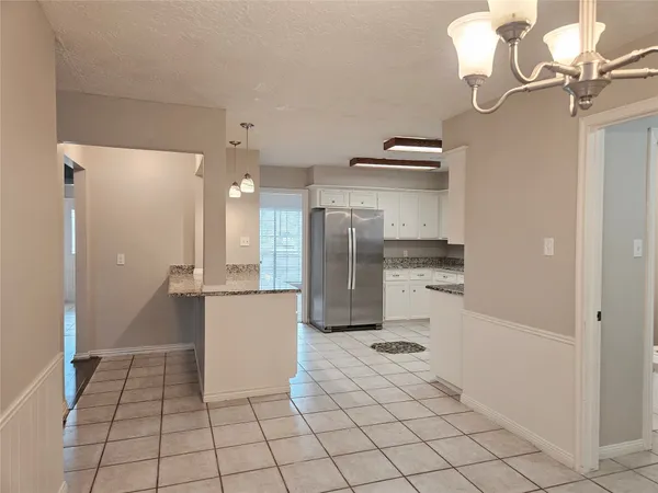 a kitchen with stainless steel appliances kitchen island granite countertop a refrigerator and a sink